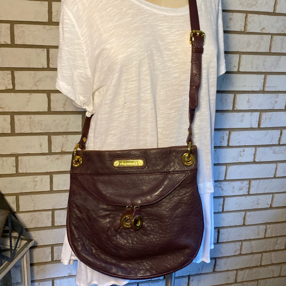 Joelle Hawkins / Purple leather purse.            10”h X  12”w. Front zip pocket